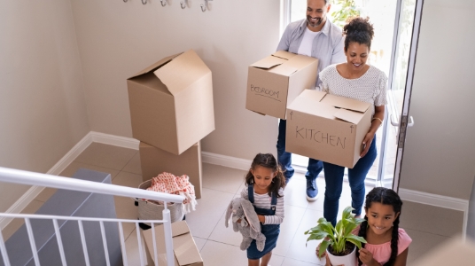 A family of four in the foyer with moving boxes
